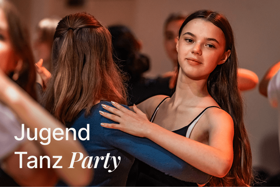 Zwei junge Frauen tanzen im Paar auf einer Tanzveranstaltung in einem warm beleuchteten Raum