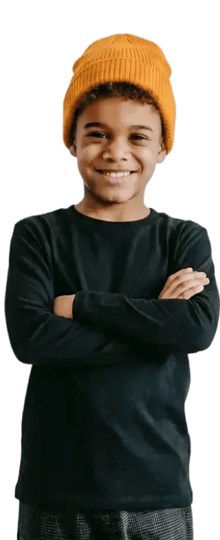 Junge mit schwarzem Langarmshirt und orangefarbener Strickmütze lächelnd mit verschränkten Armen