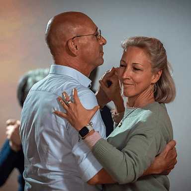 Älteres Paar tanzt eng umarmt in gemütlicher Innenraumbeleuchtung