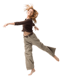 Frau mit lockigem blonden Haar tanzt leichtfüßig in braunem Pullover und beigen Hose vor weißem Hintergrund